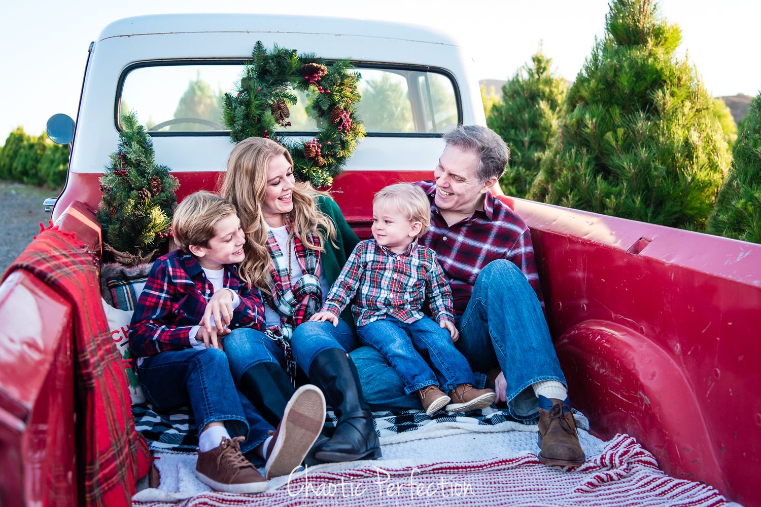 Image of a family in a vintage red truck at a christmas tree farm in Orange County, CA