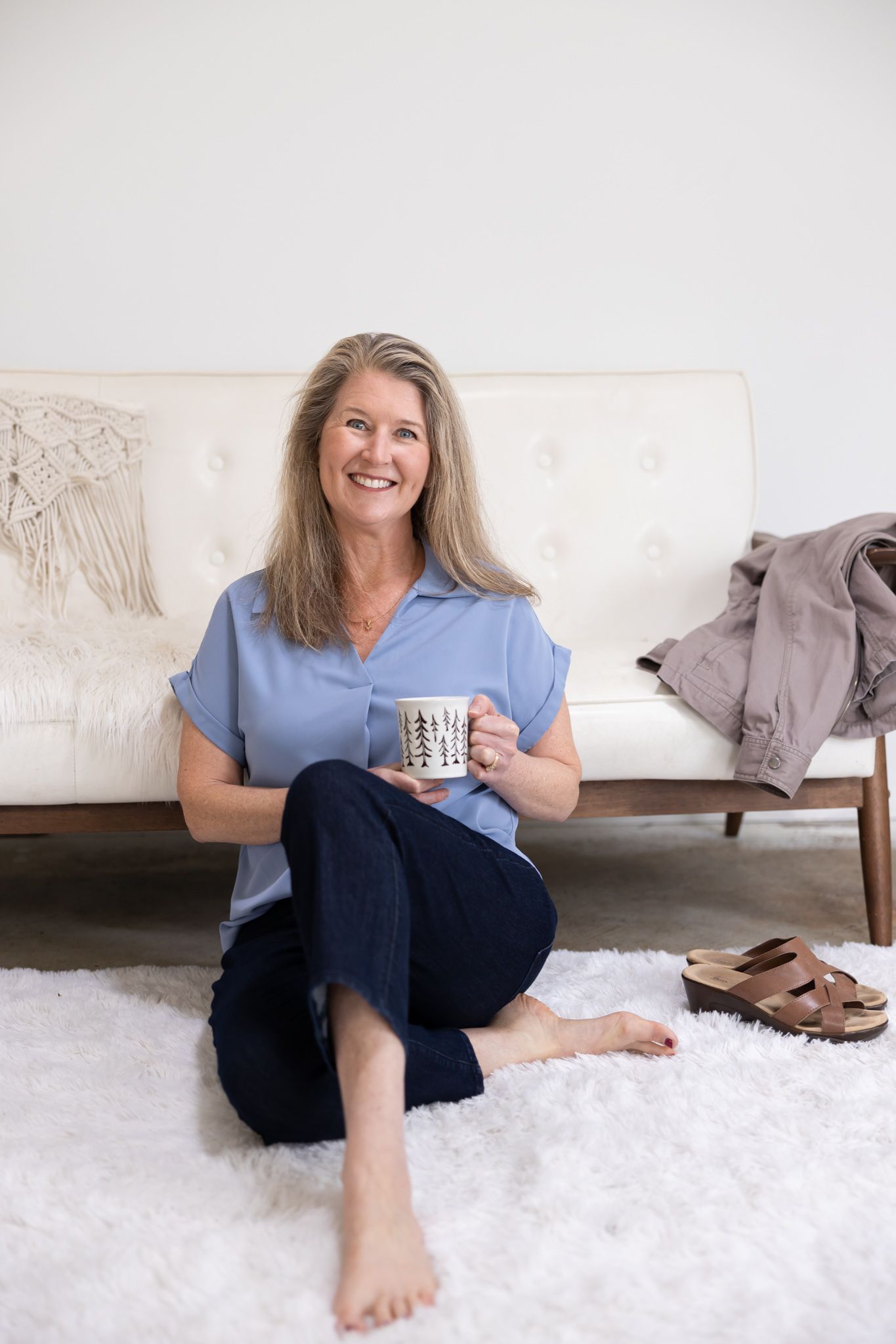 woman wellness coach sitting on ground infront of couch holding mug lifestyle headshot in Woodinville, WA