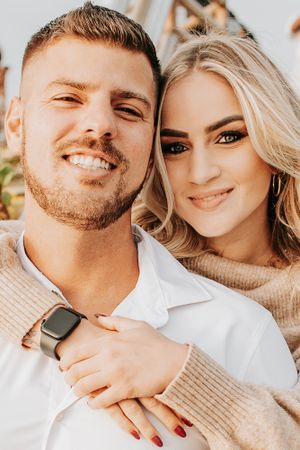 A close-up portrait of a happy couple in warm sunlight.