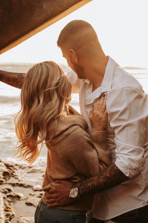 Golden hour couple photography session with ocean backdrop.