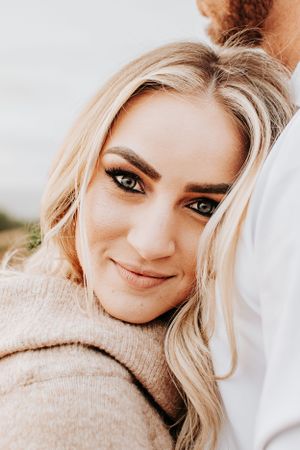 Close up portrait with natural lighting showing blonde hair and a beige sweater.