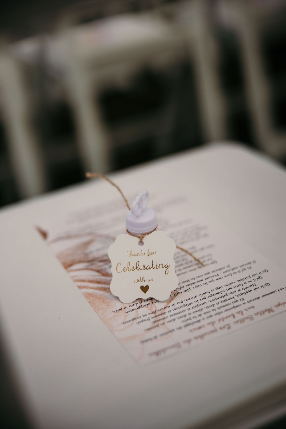An elegant wedding invitation detail with a 'Celebrating' tag on white paper.