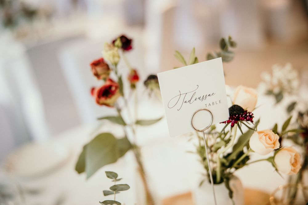 Wedding reception table detail with delicate floral arrangements and name cards.