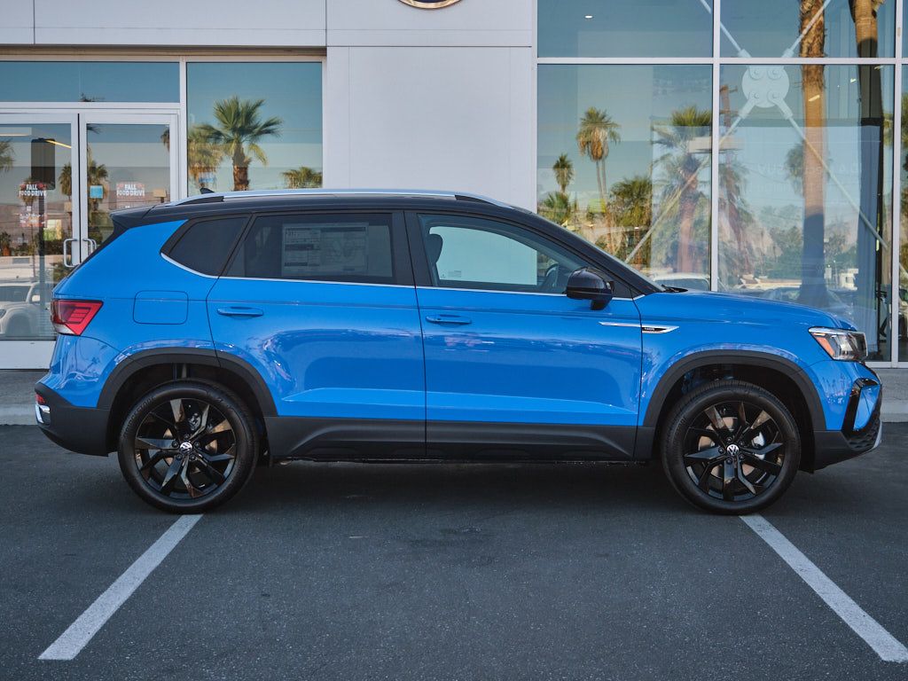 Side profile of blue Volkswagen Taos SUV with black wheels.