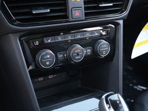 Car climate control panel with digital temperature displays and adjustment knobs.