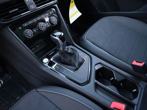 Automatic transmission gear shifter and cup holders in a car's center console.