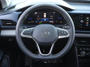 Volkswagen steering wheel with digital dashboard display in a modern vehicle interior.