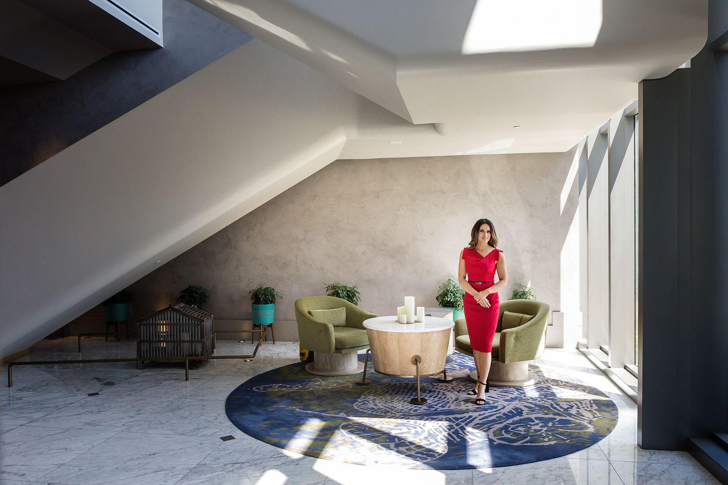 Woman in red dress standing in a modern architectural room