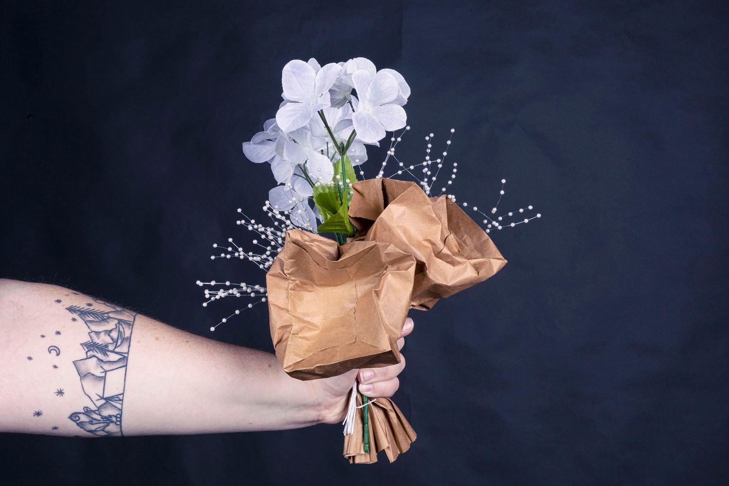 Artistic still life of dried flowers and sparkly elements against a dark background.