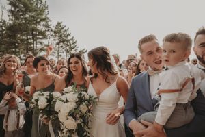 Candid moment of wedding party sharing laughs and joy during outdoor photo session.