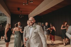 Wedding reception guests dancing and celebrating on indoor dance floor.
