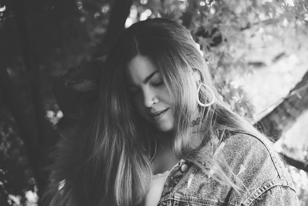 Artistic black and white photo series with dreamy bokeh effect through tree leaves.