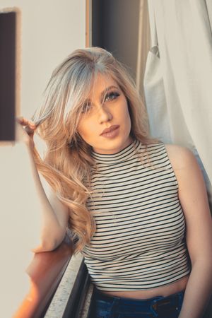 Close-up of striped top against warm lighting and neutral background.