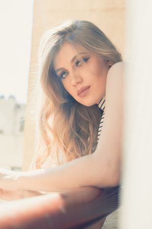 Soft focus portrait in warm natural lighting creating an ethereal mood by a sunlit window.