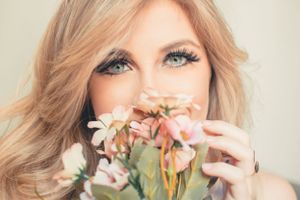 Artistic beauty portrait incorporating delicate pink and peach colored flowers.