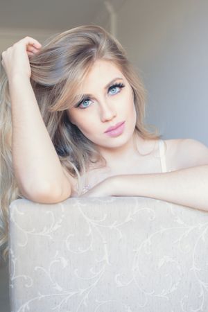 Romantic boudoir photography with soft focus and gentle natural window lighting.