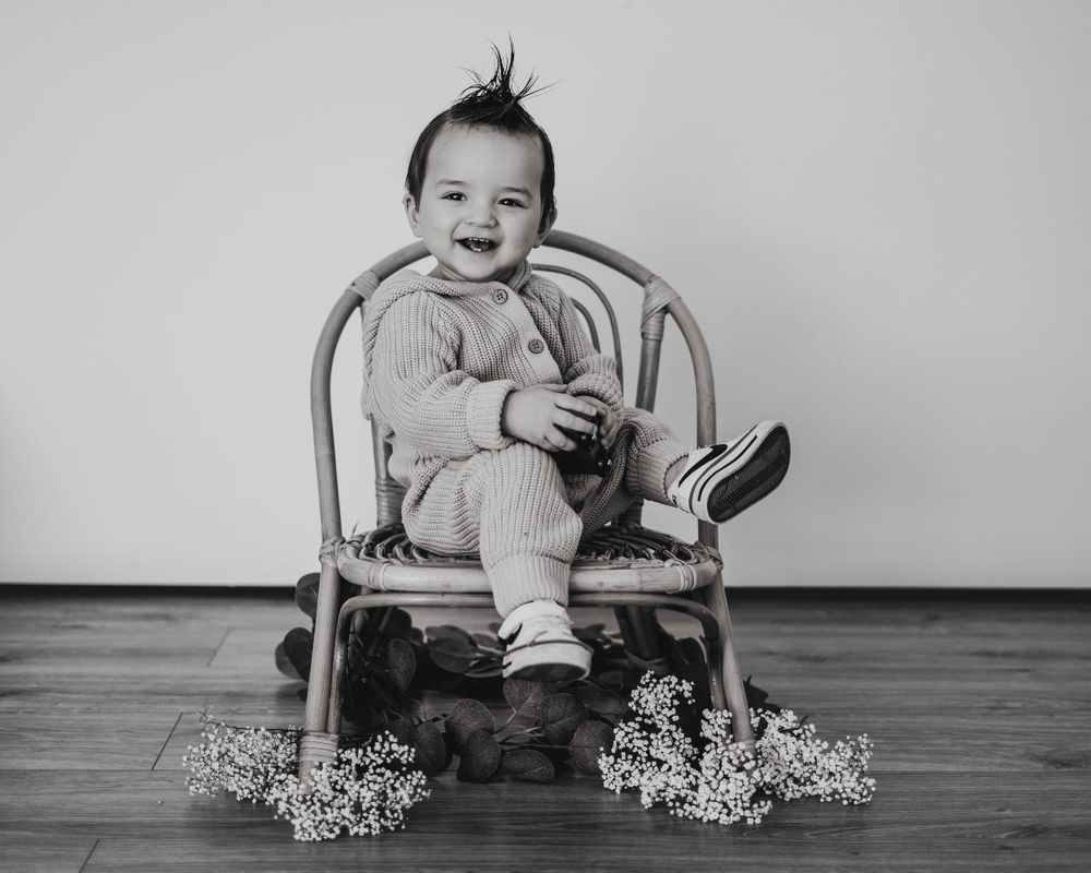 Energetic one-year-old boy photoshoot in Grand Rapids, capturing a happy baby's personality during a milestone photography session.