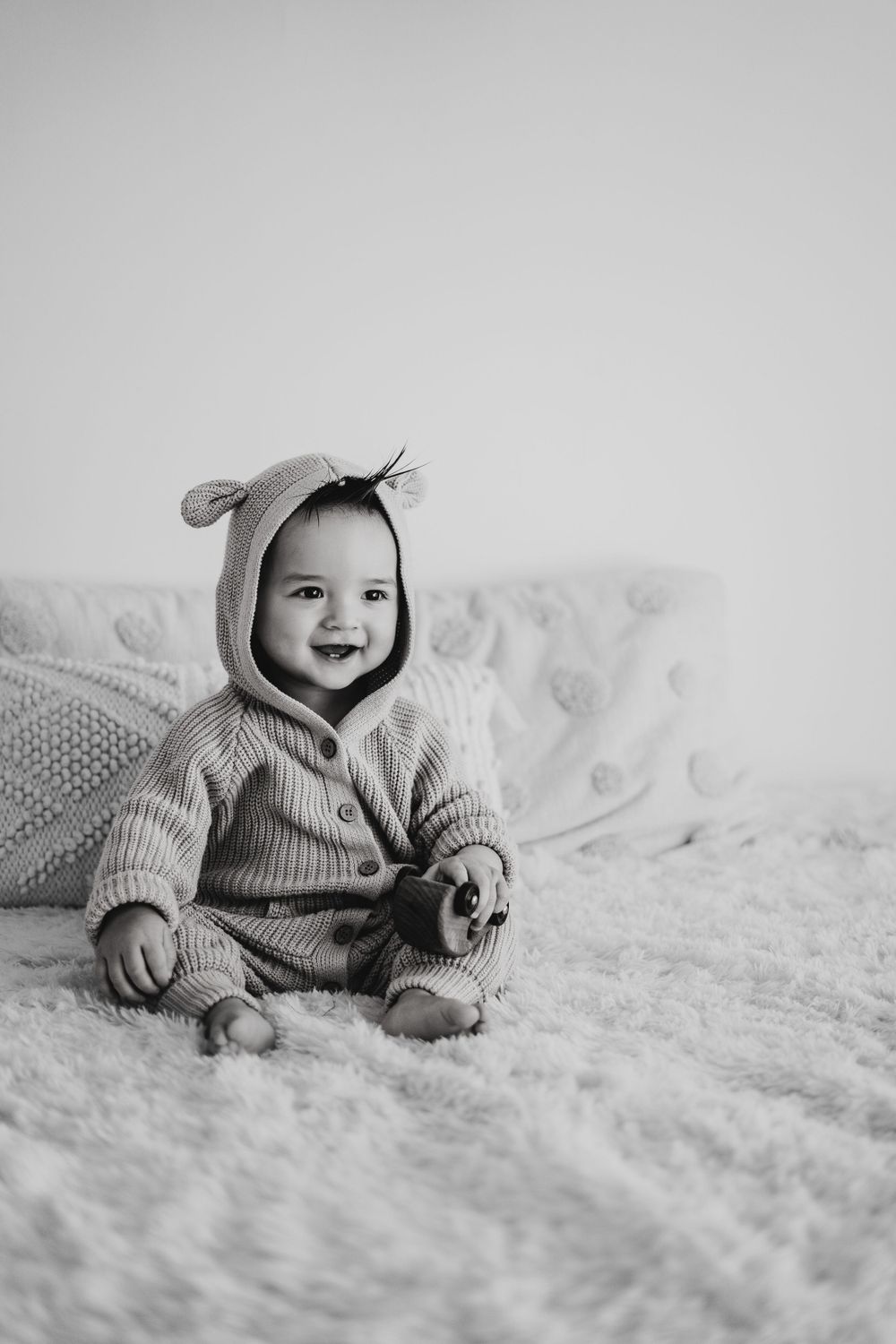 Energetic one-year-old boy photoshoot in Grand Rapids, capturing a happy baby's personality during a milestone photography session.