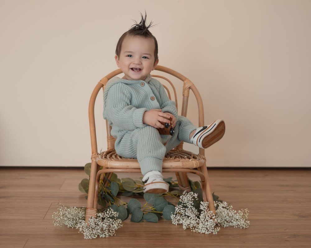 Energetic one-year-old boy photoshoot in Grand Rapids, capturing a happy baby's personality during a milestone photography session.