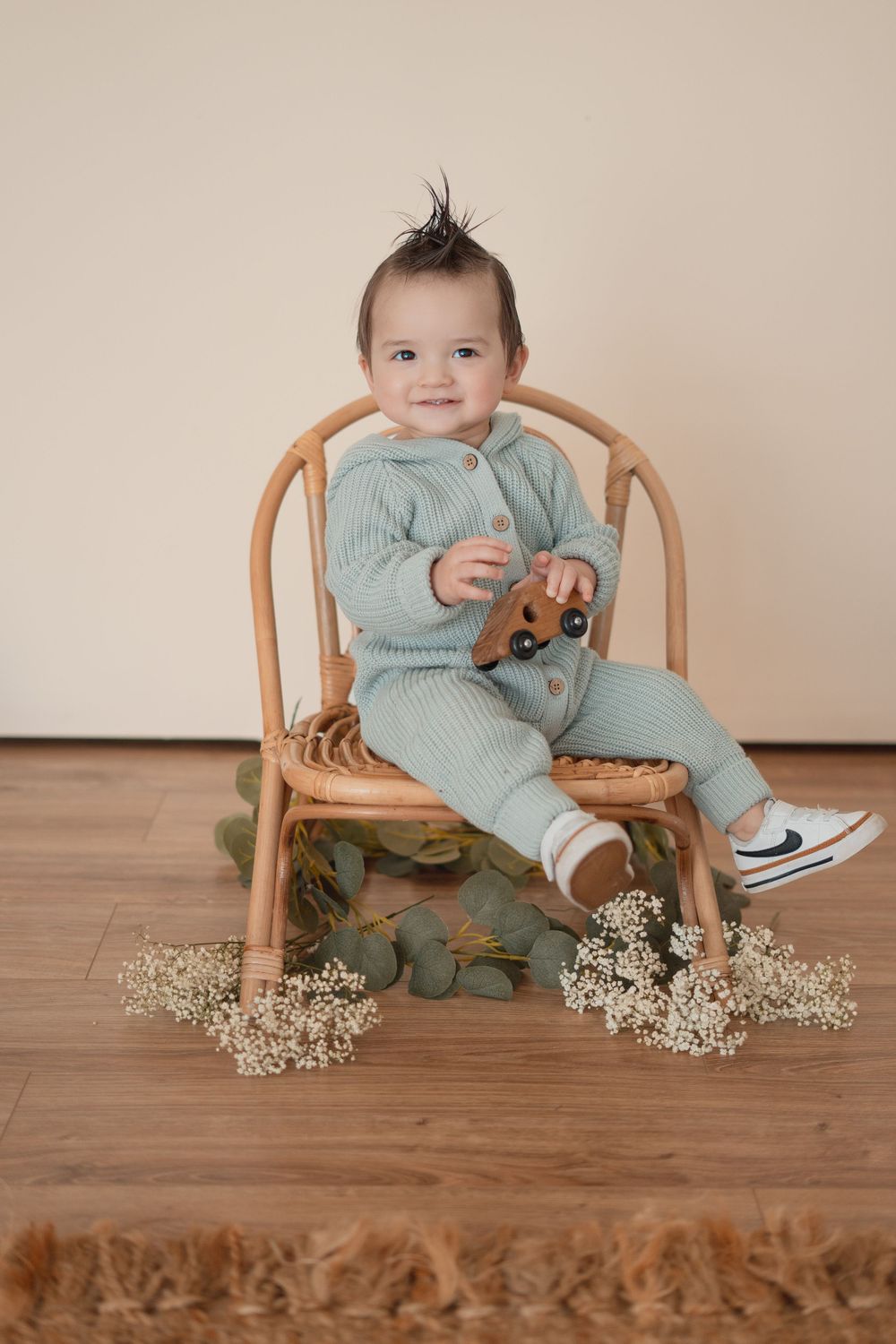 Energetic one-year-old boy photoshoot in Grand Rapids, capturing a happy baby's personality during a milestone photography session.