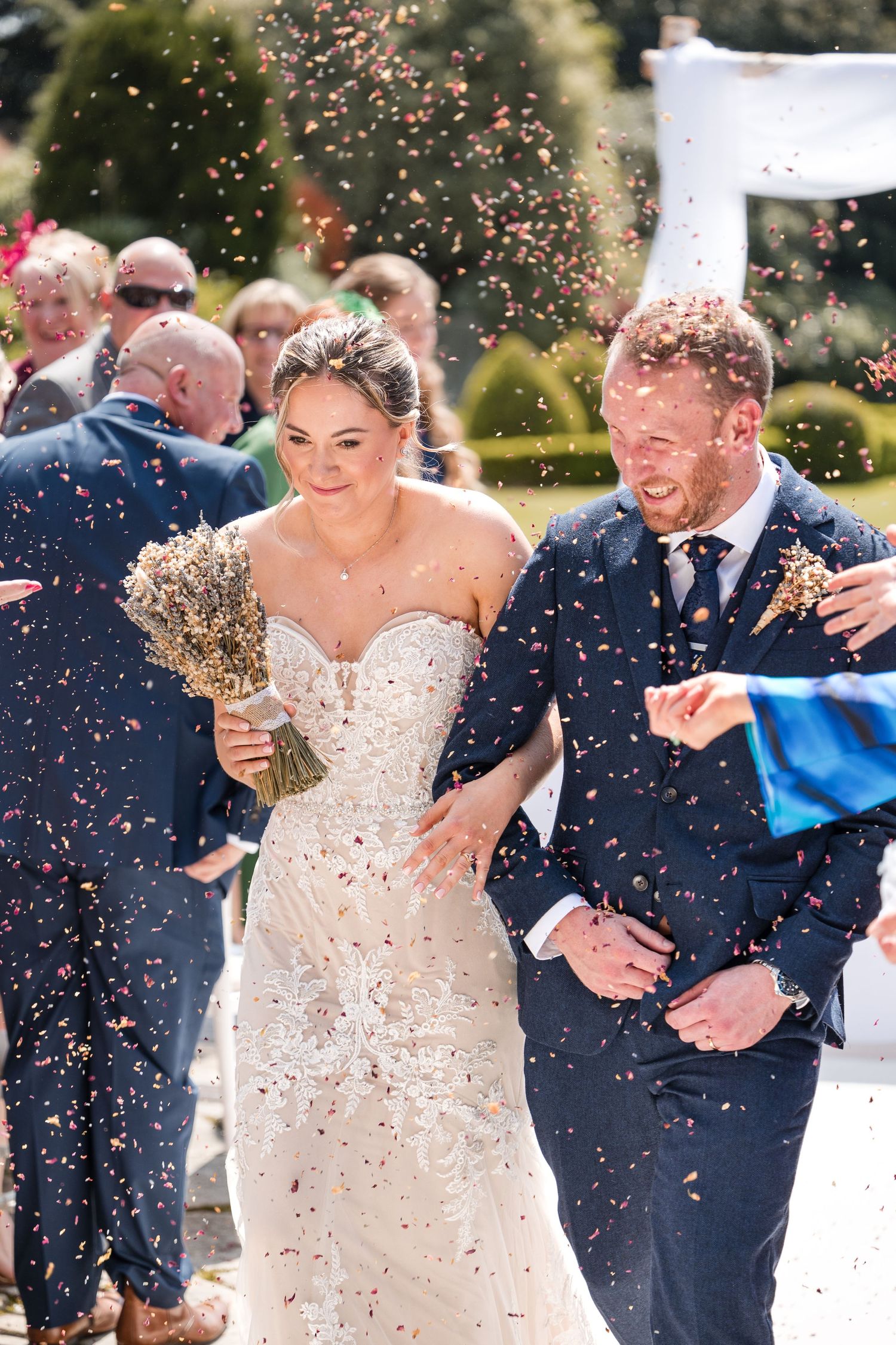 bride and groom walking down the isle surrounded in confetti