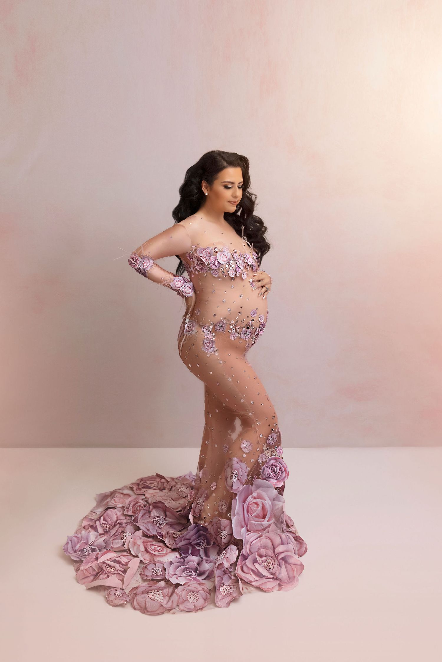 Artistic maternity portrait in a sheer lavender gown with rose petal details and flowing train.