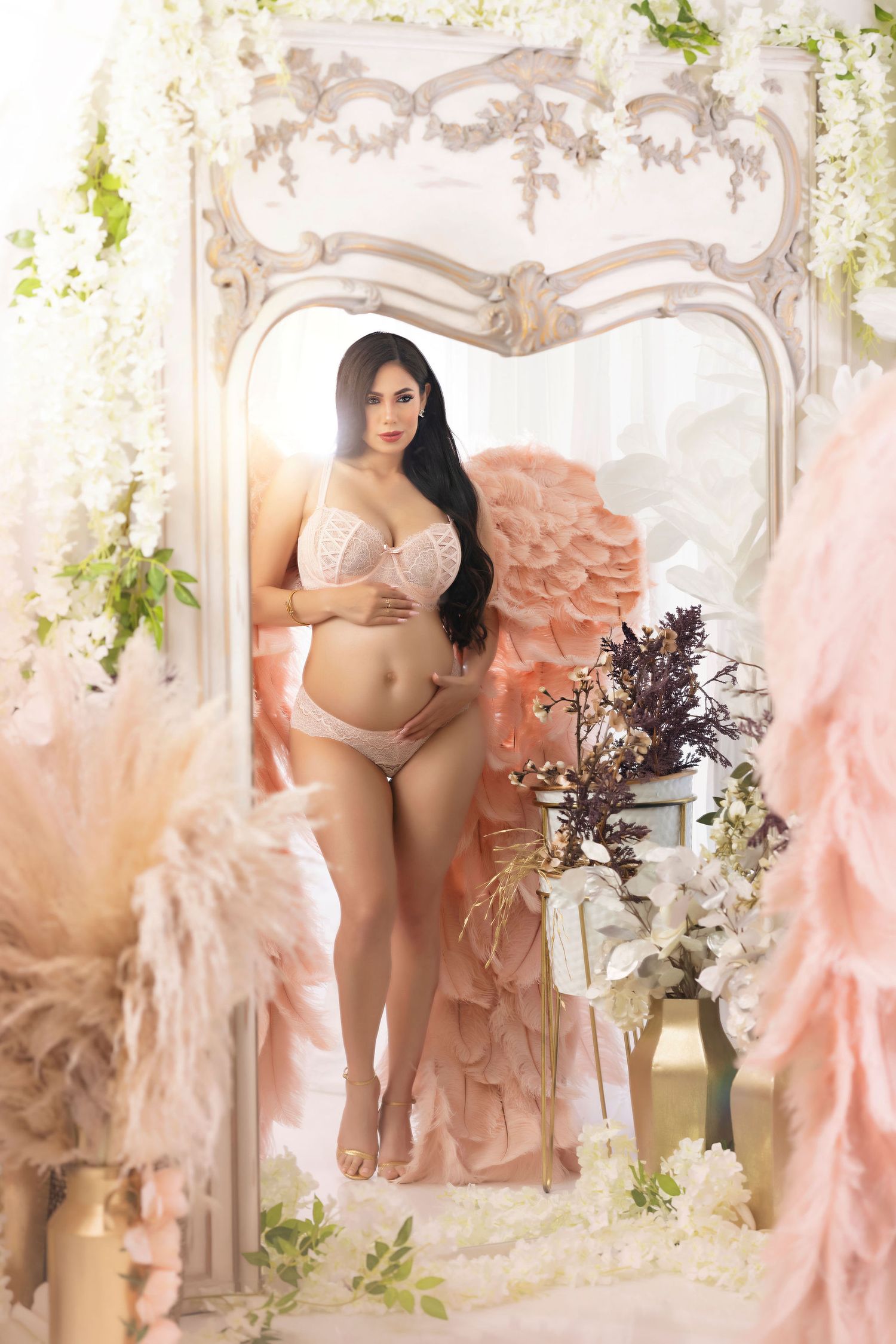 Elegant boudoir photo in ornate white frame with floral decorations.