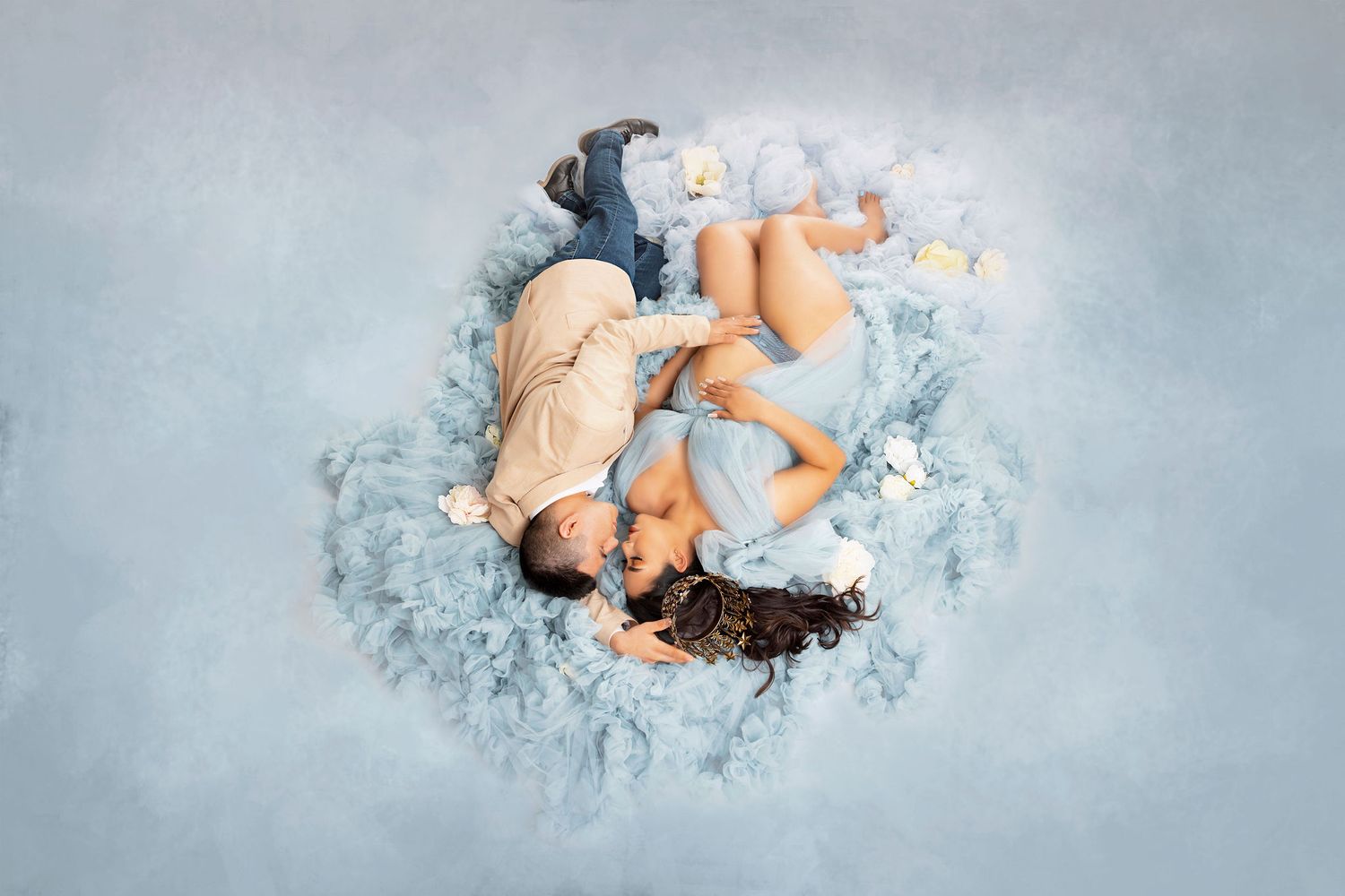 Artistic overhead maternity photo with blue and white tones on textured background.