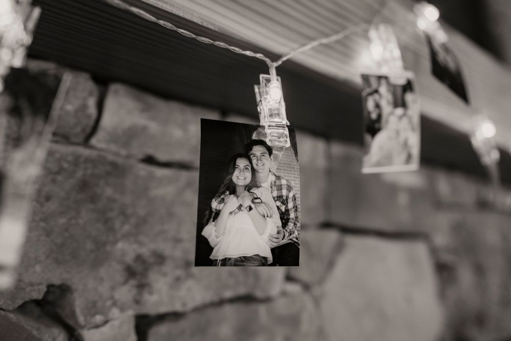 A vintage black and white photograph hangs from a string with clothespins.