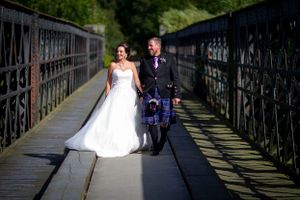 wedding couple walking along a bridge