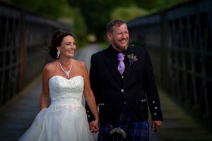 wedding couple walking along a bridge