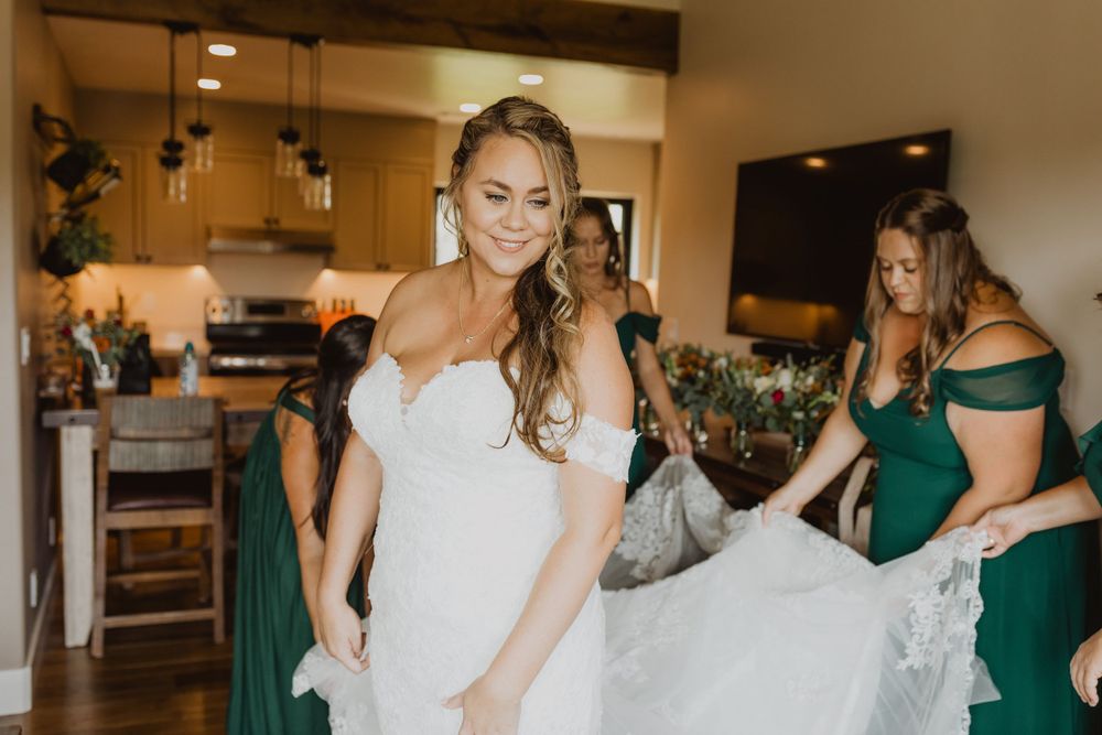 Wedding party members in white and emerald green dresses gather together during preparation.