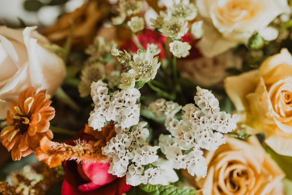 Close-up of wedding bouquet featuring peach roses and delicate white flowers.