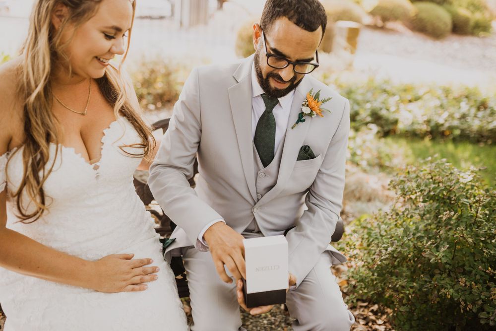 A romantic wedding moment captured in golden sunlight among garden greenery.