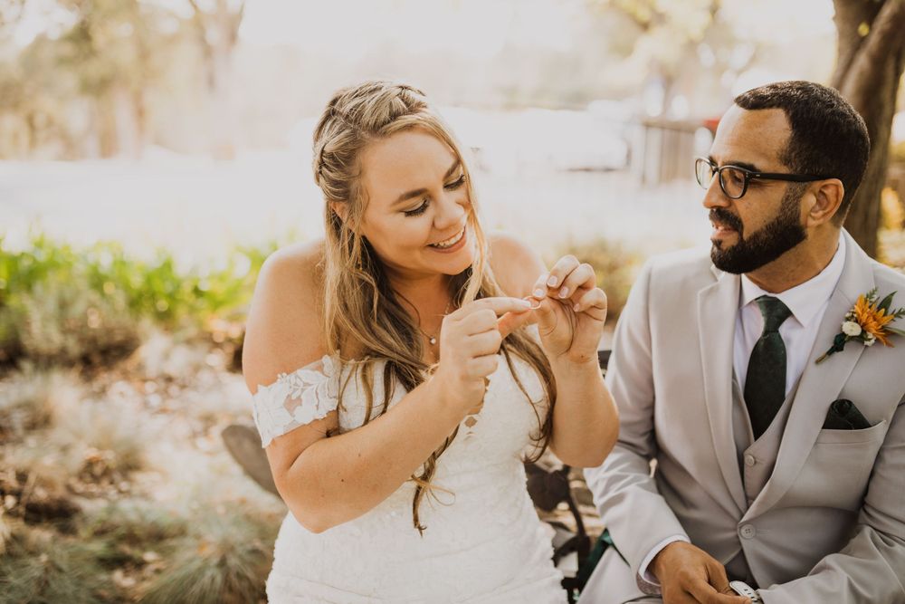 Bride and groom share joyful laughter during outdoor wedding portraits.