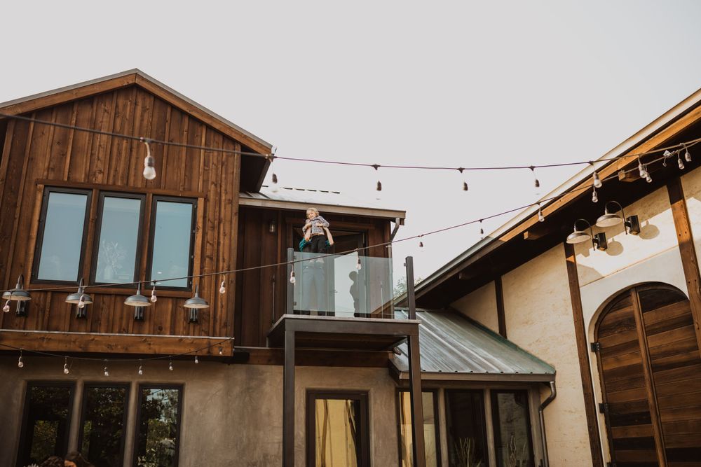 Wooden barn-style wedding venue with string lights and modern architectural elements.