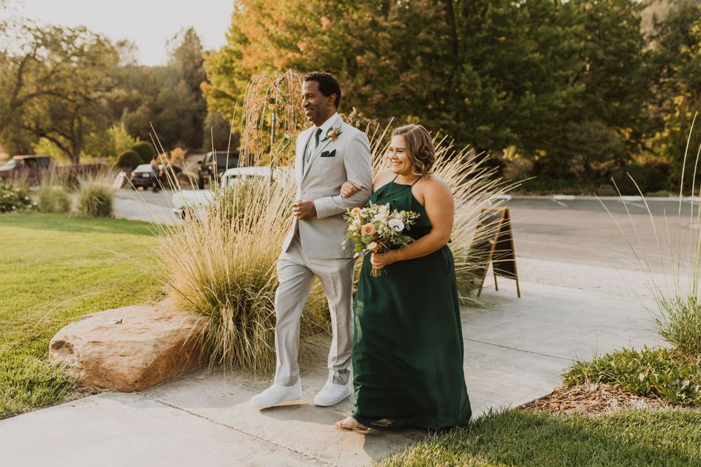 Couple sharing a romantic moment on an outdoor path with fall foliage in the background.