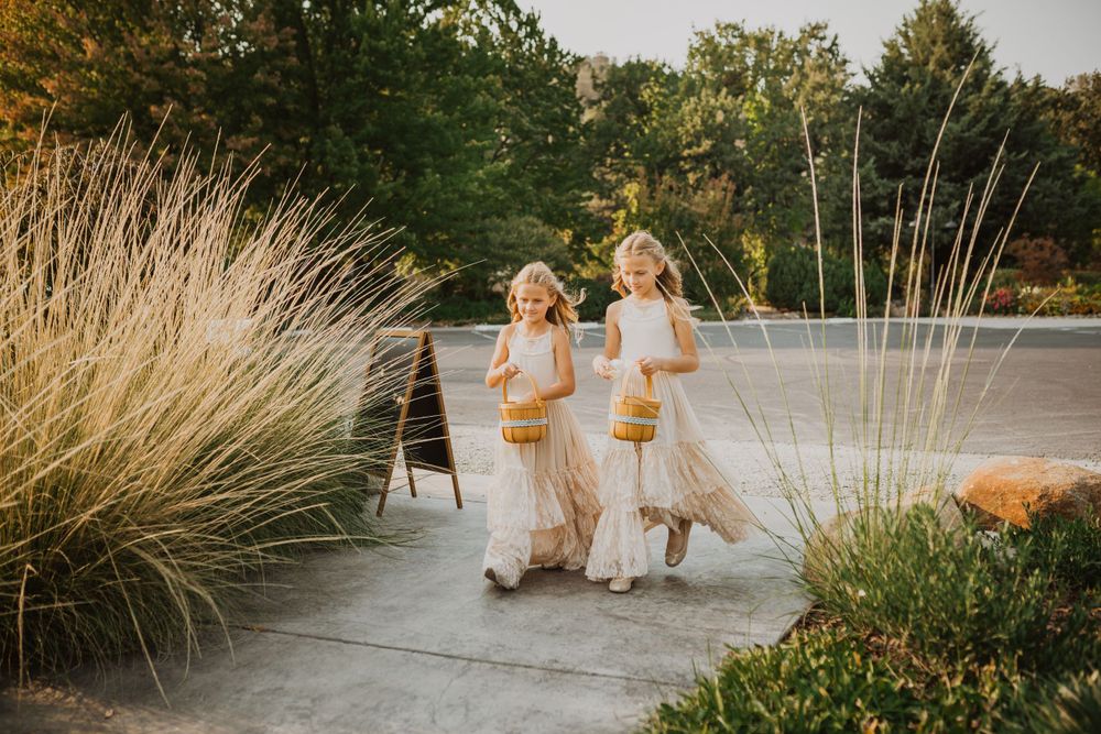 Couple walking along a scenic garden path with ornamental grasses and natural landscaping at sunset.