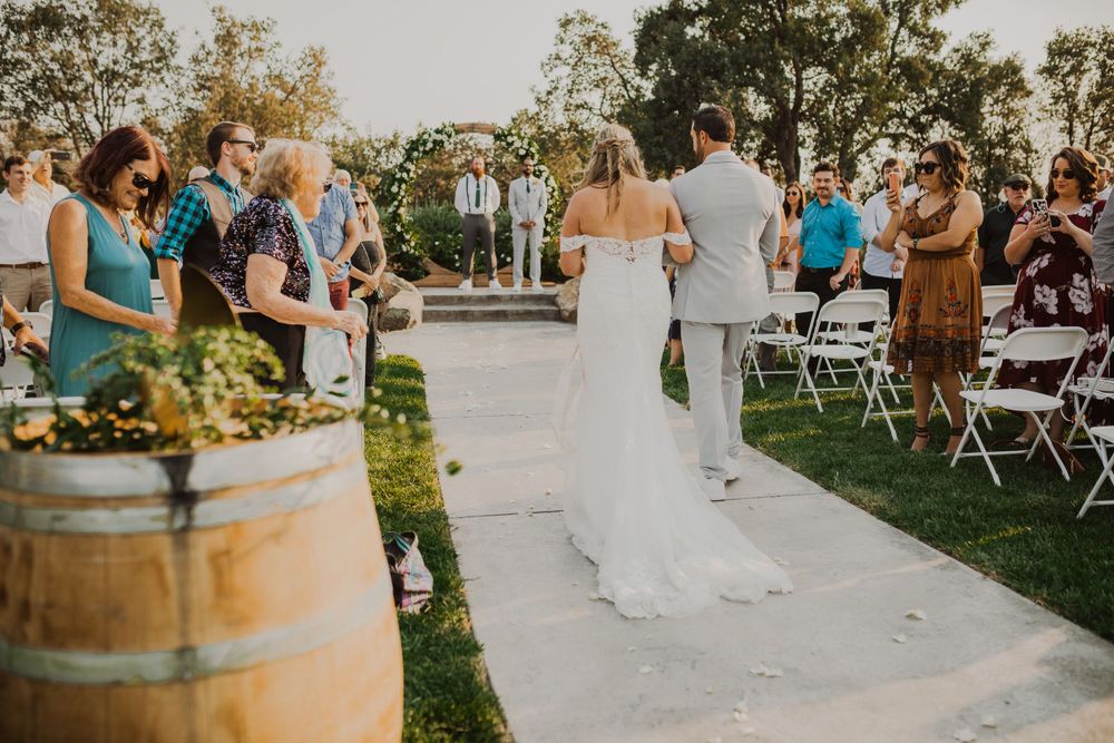 Wedding reception setup with rustic wine barrels and outdoor seating arrangements.