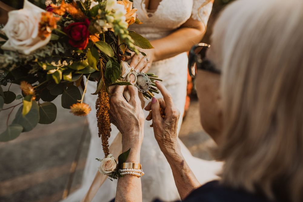 Close-up of autumn-colored wedding bouquet with roses and greenery.