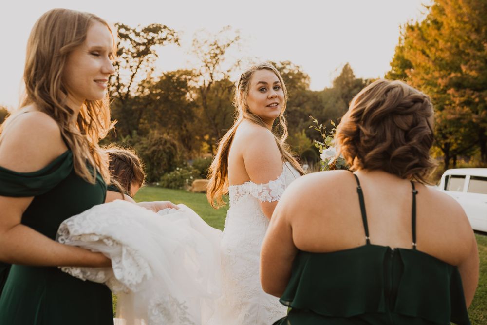 Newlyweds share intimate moments in a garden setting during sunset.