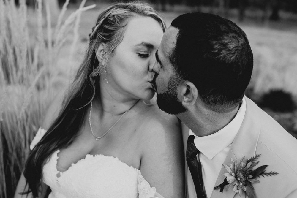 Black and white portrait of newlyweds sharing tender moments during their wedding photoshoot.