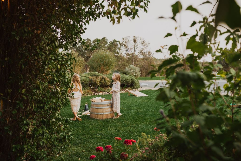 Outdoor garden wedding ceremony setup with wine barrel and floral arrangements.