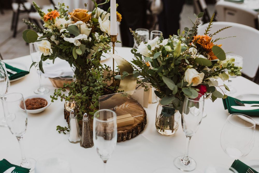 Rustic wedding centerpiece with wildflowers on wood slice charger.
