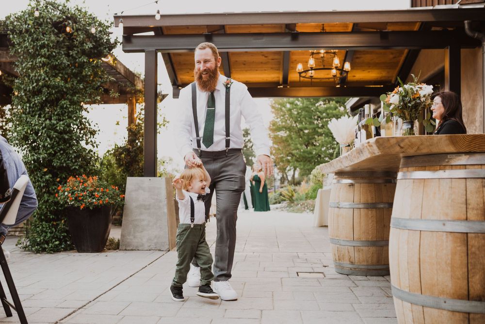 A charming outdoor wedding moment featuring wine barrels and warm lighting under a covered patio.