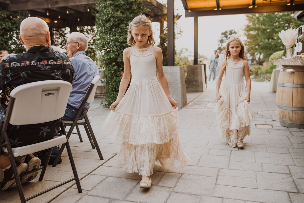 A delicate outdoor wedding celebration with string lights and rustic decor elements.