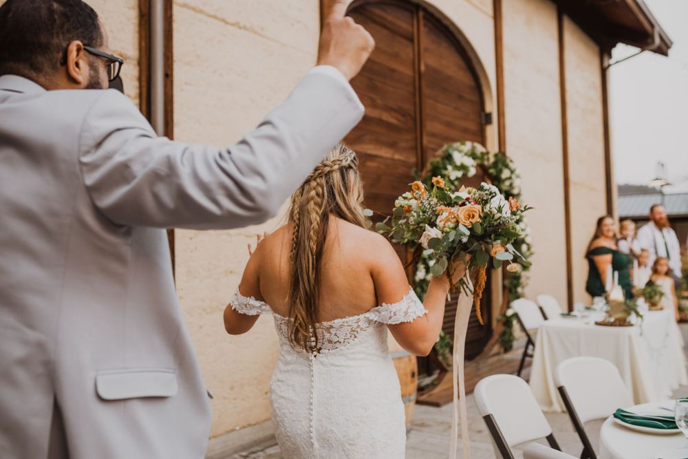 A candid wedding moment captured against rustic architecture and elegant decor.