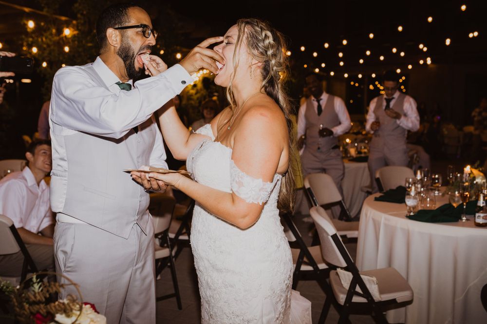 Wedding reception scene with string lights and guests celebrating at round tables.
