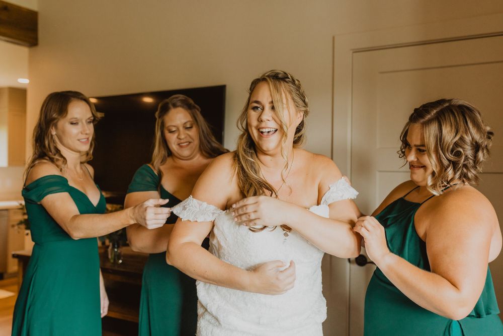 Candid moments of wedding party members getting ready in emerald robes.