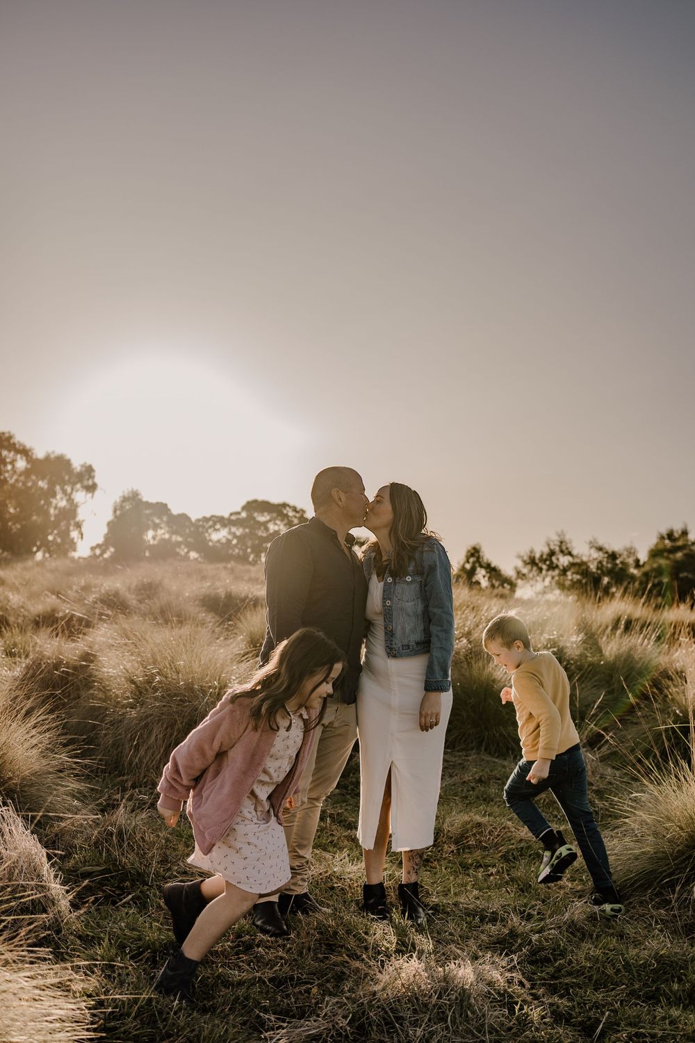 Candid family moment captured during golden hour in a natural outdoor setting.